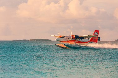 Ari Atoll, Maldivler - 06.01.2019: Maldivler 'de deniz uçağıyla yapılan egzotik sahneler. Maldivler 'de tatil ya da tatil kavramı. Güzel günbatımı fotoğrafı. Egzotik ulaşım, deniz uçağı gibi havayolu.