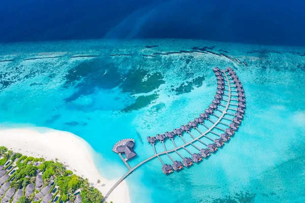 モルディブ島 豪華なウォーターヴィラリゾートと木製の桟橋の空中ビュー 美しい空と海のラグーンのビーチの背景 夏休み休暇と旅行のコンセプト パラダイス航空風景パノ — ストック写真