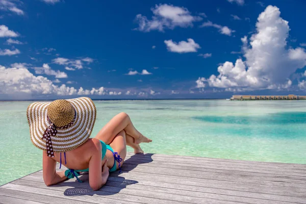 Maldivler sahilinde bikinili genç bir kadın.