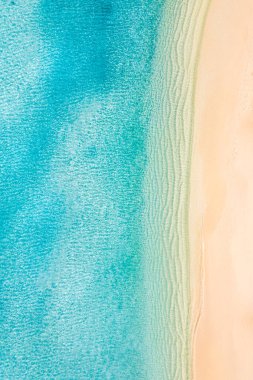 Temiz beyaz kum ve turkuaz suların havadan görünüşü.