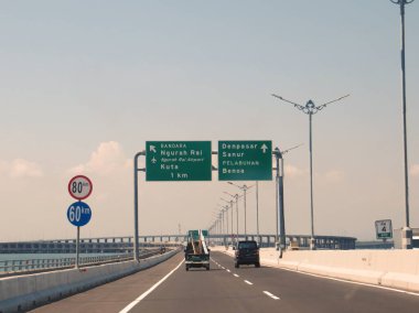 Badung Bali, Endonezya - 3 Ekim 2019: Benoa Körfezi boyunca uzanan 12.7 km uzunluğunda bir köprüden geçen Bali Mandara Toll Yolu 'ndan geçen araçlar.