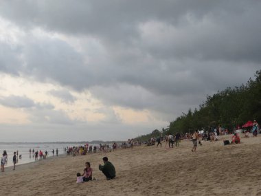 Badung Bali, Endonezya - 4 Ekim 2019: İnsanlar gün batımında Kuta Sahili 'nde takılıyor.