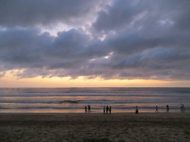 Badung Bali, Endonezya - 4 Ekim 2019: İnsanlar gün batımında Kuta Sahili 'nde takılıyor.