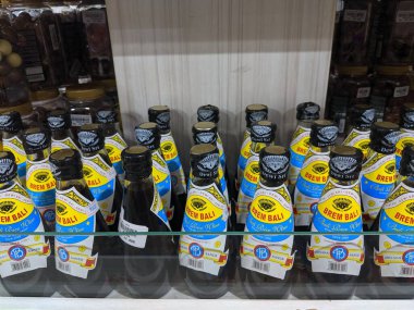 Denpasar, Endonezya - 12 Ekim 2019: Bir hediyelik eşya dükkanının rafında sıra sıra Brem Bali (Bali pirinç şarabı) şişeleri. Brem, Bali 'den gelen pirinç şarabından yapılan geleneksel mayalanmış içecektir..