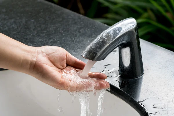 Faucet with woman hand — Stock Photo, Image