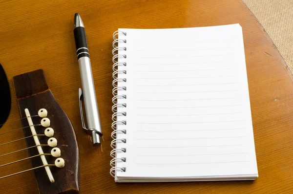 Blankt papper med penna på gamla akustisk gitarr — Stockfoto