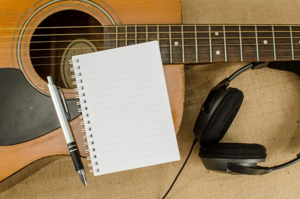 Blank paper with pen on old acoustic guitar — Stock Photo, Image