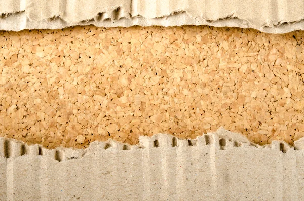Papel ondulado marrón sobre fondo de corcho — Foto de Stock