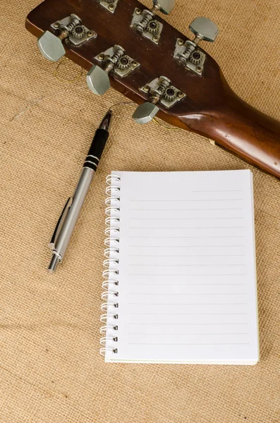 Blank paper with pen on old acoustic guitar — Stock Photo, Image