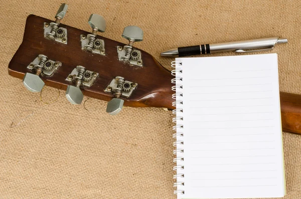 Blank paper with pen on old acoustic guitar — Stock Photo, Image