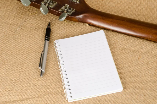 Papel em branco com caneta na guitarra acústica antiga — Fotografia de Stock