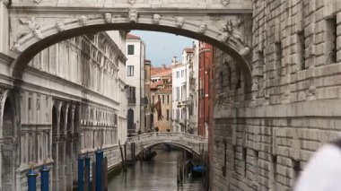 İnsanlar geleneksel Venedik kanalının önünden geçiyor.