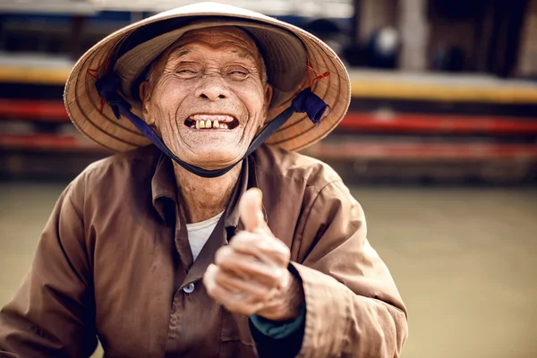 Oude man op een boot in rivier, vietnam. — Stockfoto