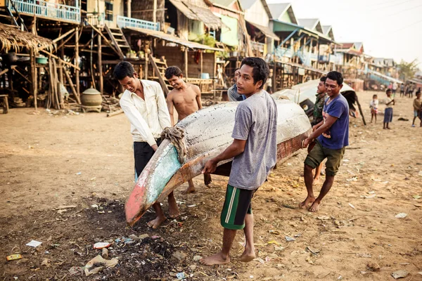 Oidentifierade khmer människor reparera deras bot på Tonle underminerar laken. — Stockfoto