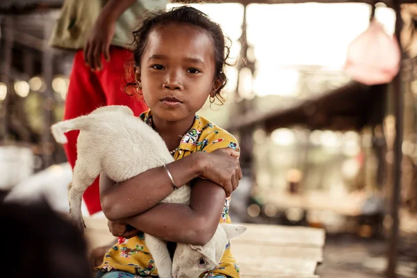 Неопознанная маленькая азиатская девочка держит собаку в руках в деревне Тон-ле-Соп. , — стоковое фото