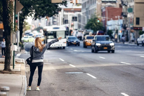 Mujer deteniendo taxi — Foto de Stock