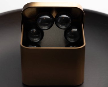 Parlak siyah manyetik küreleri olan metalik bir kutunun minimalist yakın çekimi modern ve soyut bir görsel estetik yaratıyor..