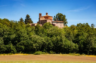 Ortaçağ evleriyle çevrili Toskana tepelerinin panoramik manzarası.