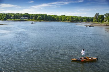 KENNEBUNK, ME - 10 HAZİRAN 2021: Okyanusta bir kanoda balık tutan adam, Kennebunk ME, Amerika 'da kayak yapan balıkçı