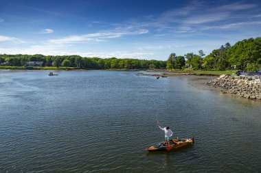 KENNEBUNK, ME - 10 HAZİRAN 2021: Okyanusta bir kanoda balık tutan adam, Kennebunk ME, Amerika 'da kayak yapan balıkçı