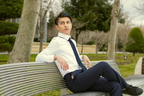 Trandy adolescent guy assis sur un banc — Photo