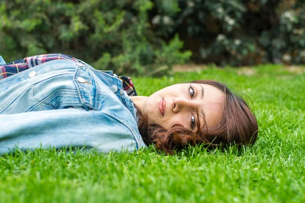 Wanita muda yang cantik beristirahat di rumput — Stok Foto