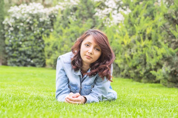 Hermosa mujer joven descansando sobre la hierba — Foto de Stock