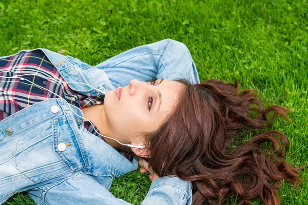 Hermosa mujer joven descansando sobre la hierba — Foto de Stock