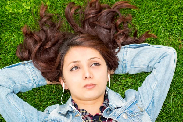 Beautiful young woman resting on the grass — Stock Photo, Image