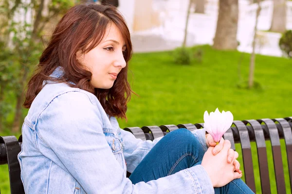 Beautiful woman sitting on a bench — Stock Photo, Image