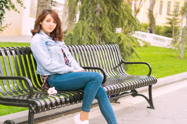 Krásná žena, sedící na lavičce — Stock fotografie