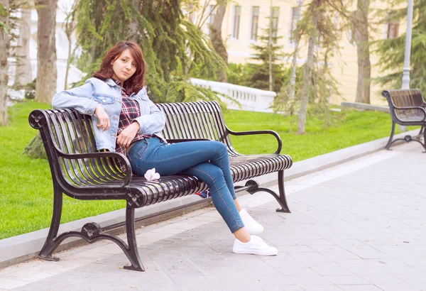 Mulher bonita sentada em um banco — Fotografia de Stock