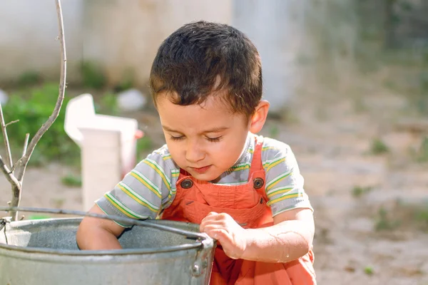 Little boy plays with water — Stock Photo, Image