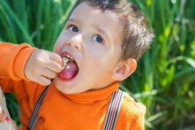 Çocuk patlamış mısır ağzına koyar.