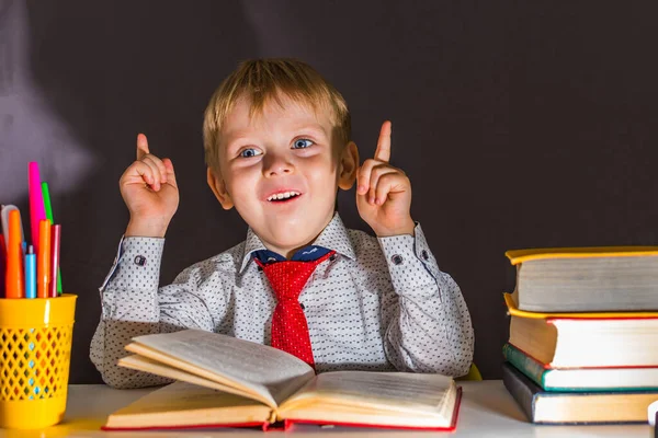 Cheerful Preschool Boy Sitting Table Books Black Background — Stock Photo, Image