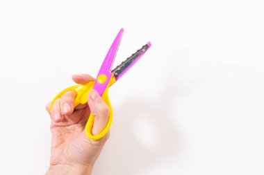 Beyaz arkaplanda elinde kıvrımlı kağıt makas