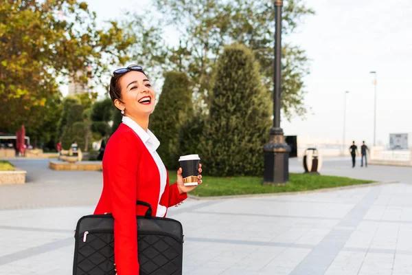 公園にノートパソコンとコーヒーを持った幸せな女性が — ストック写真