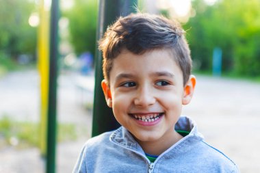 Neşeli küçük bir çocuk evin yakınındaki bahçede oynuyor..