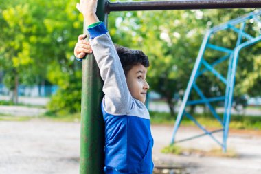 Neşeli küçük bir çocuk evin yakınındaki bahçede oynuyor..