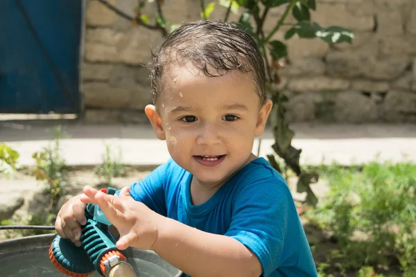 A boy plays with water — Stock Photo, Image