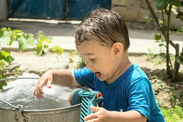 A boy plays with water — Stock Photo, Image