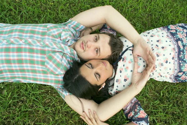 Mladý pár ležící na trávě — Stock fotografie