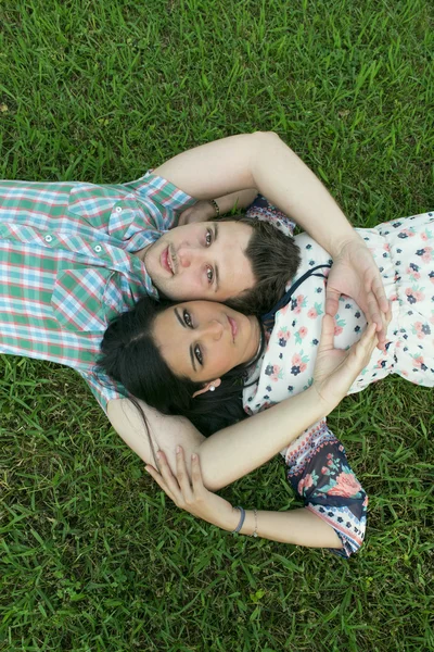 年轻夫妇躺在草地上 — 图库照片