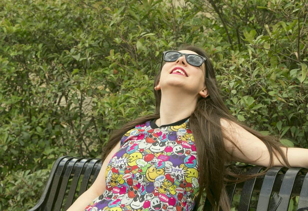 La ragazza sulla panchina con gli occhiali da sole — Foto Stock