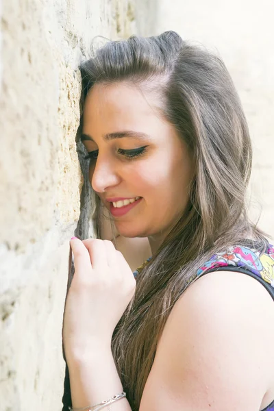 The girl leaned against the stone wall — Stock Photo, Image