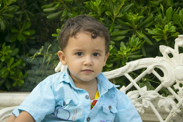 Niño 2 años sentado en un banco — Foto de Stock