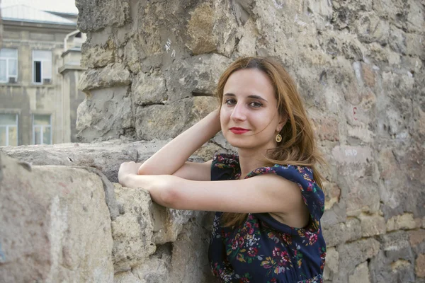 Giovane ragazza vicino a un muro di pietra — Foto Stock