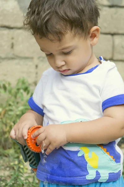 Boy playing with garden hose — Stock Photo, Image