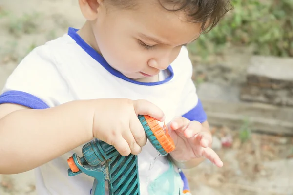 Junge spielt mit Gartenschlauch — Stockfoto