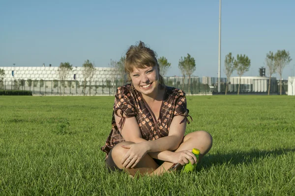 Grosse femme assise sur l'herbe verte — Photo